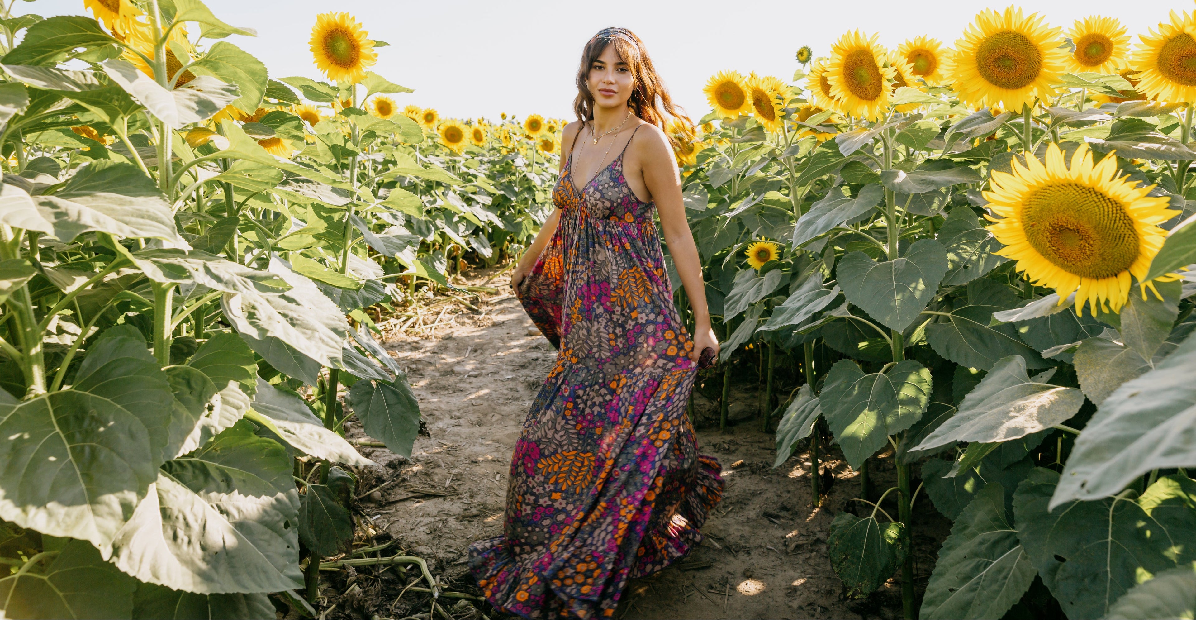 woman-in-a-floral-dress-stands-in-a-sunflower-field